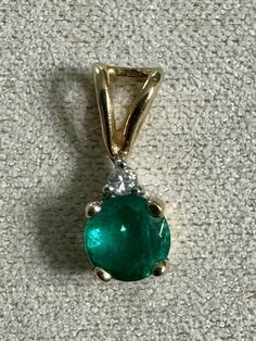 Vintage Emerald and Diamond 14K Yellow Gold Pendant - Dainty Gift for Her, anniversary jewelry, birthday present, Mother's Day necklace Material: 14K yellow gold Gemstones:  4.4mm genuine round cut Emerald and 1.2mm round cut genuine Diamond Weight: 0.5 grams  Stamped: 14K Condition: vintage/pre-owned good condition - Only one available *Please note that due to the nature of being a vintage piece, the pendant is slightly bent to one side as pictured. Any jeweler could adjust gently.  Please note Hallmarked Emerald Necklace For Anniversary, Exquisite Emerald Necklace With Diamond Cut For Anniversary, Green Round Cut Necklace For Anniversary, Classic Hallmarked Emerald Necklace For Anniversary, Exquisite Brilliant Cut Emerald Necklace Gift, Green Diamond Cut Necklace For Anniversary, Brilliant Cut Emerald Necklace For Anniversary, Anniversary Green Diamond Cut Necklace, Exquisite Hallmarked Emerald Necklace In Yellow Gold