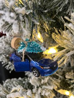 a blue car ornament hanging from a christmas tree