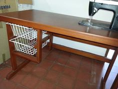 a sewing machine sitting on top of a wooden table next to a shelf with baskets