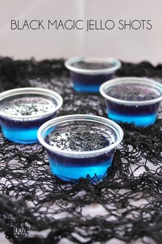 black magic jello shots in blue cups on a lace tablecloth with text overlay that reads, black magic jello shots