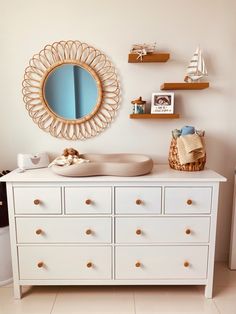 a white dresser with a mirror above it