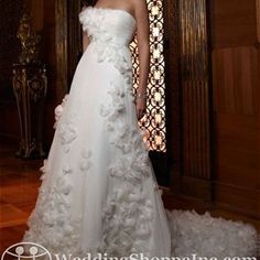 a woman in a white wedding dress standing next to a stained glass window with flowers on it