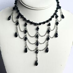 Unveil your dark, elegant side with this 16" dramatic black Gothic romance choker. This striking, one-of-a-kind piece features faceted black crystals and three rows of swagged silver chain, each adorned with teardrop crystals and faceted rondelles for a luxurious finish. The choker fastens securely with a lobster clasp closure, but if you'd like it to hang longer, just message me for custom chain adjustments. Perfect for adding a bold, Gothic touch to any outfit. Wedding Jewelery, Custom Chain, Gothic Romance, Diy Jewelry Unique, Romantic Goth, Silver Chains, Accessories Jewelry Earrings, Beads And Wire, Faceted Crystal