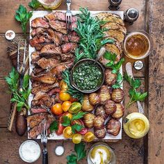 a wooden table topped with meat and veggies