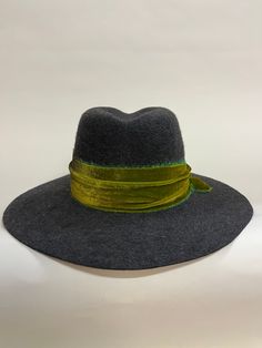 "Buck's Fizz" one-of-a-kind wide flat-brim fedora, in charcoal heather fur felt. Trimmed with a length of gorgeous raw-edge tie-dye silk velvet and an antique mother-of-pearl button. This fedora features a crown with blunt lines and a flat cut-edge brim: simple but assertive. 22.5" headsize, with comfortable adjustable grosgrain inner band. Crown 4.25"H at CF, 4"H at sides; 3.75"W brim. Hand-blocked and finished by me, in my millinery studio.  $415. Includes free shipping (within contiguous US only). Felt Fedora, Boulder Co, Silk Dyeing, Mother Of Pearl Buttons, Silk Velvet, Wide Brimmed, Raw Edge, 4 H, Fedora