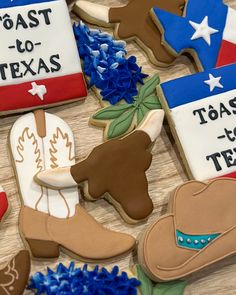 decorated cookies are arranged on a table with blue flowers and texas themed cookies in the shape of cowboy boots