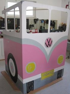 a pink and gray bus shaped ice cream stand in a room with lots of windows