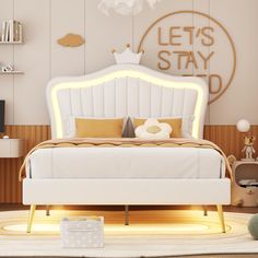 a white bed sitting on top of a wooden floor next to a wall mounted clock