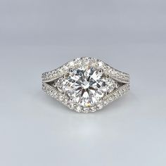 a diamond engagement ring with two rows of diamonds on the band and an oval shaped center stone