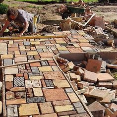 a man is working on a pile of bricks