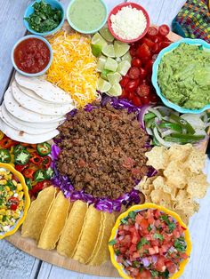 a platter filled with tacos, guacamole and tortilla chips