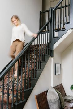 a woman is walking down the stairs in her home