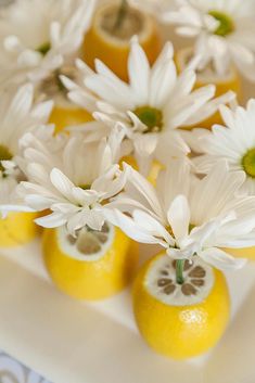 there are lemons and daisies on the table