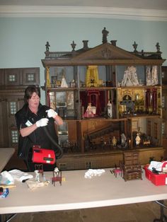 a woman standing in front of a table holding a nintendo wii game controller