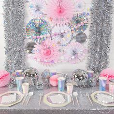 a table set up for a party with pink, silver and white decorations on it