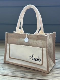 a personalized jute tote bag on a wooden deck with the name sophie