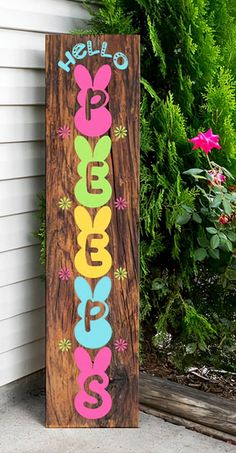 a wooden sign that says hello peebees on it's side in front of a house