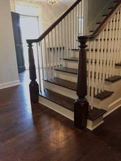 the stairs in this house are made of wood and have white railings with black balconies