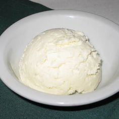 a white bowl filled with whipped cream on top of a table