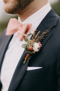 a man in a suit with a bow tie and flower boutonniere on his lapel