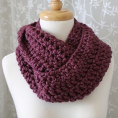 a close up of a mannequin wearing a purple knitted cowl scarf