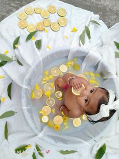 a baby in a bath filled with lemon slices