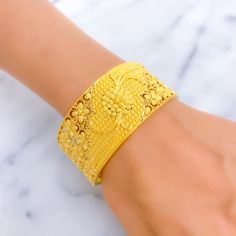 Crafted from 22k gold with a weight of 45.5 grams, this bangle radiates elegance with its polished yellow gold finish. It features a distinctive netted flower design, combining artistic craftsmanship with a touch of nature's beauty. The bangle measures 2.6 inches in size with a 2.35-inch opening, equipped with a screw and hinge for secure and comfortable wear. Perfect for those who appreciate intricate details and timeless floral motifs, this piece adds a luxurious and refined element to any jew Yellow Bangle With Intricate Design, Gold-plated Yellow Bangle With Intricate Design, Yellow Gold Plated Bangle With Intricate Design, 22k Gold Filigree Bangle In Yellow Gold, Yellow Gold Bangle Bracelet With Intricate Design, 22k Yellow Gold Filigree Bangle, Yellow 22k Gold Bangle With Intricate Design, Yellow Bangle Bracelet With Intricate Design, Yellow Bangle Bracelets With Intricate Design