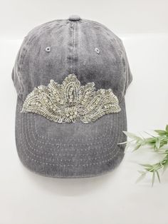 This is a new product from Handmade MKE! This is a distressed gray one size fits all baseball cap with a hole for your ponytail in the back, it is also adjustable. On the front of the hat is large rhinestone beaded applique in a beautiful art deco design. This is very comfortable, and great to throw on with a plain white T-shirt! Like our Facebook Page and get 10% off when you message me before checkout! Everything made by handmade MKE is one of a kind and unique, however, if you would like a di Adjustable Rhinestone Baseball Cap With Curved Brim, Adjustable Rhinestone Cap, Embellished Adjustable Hat With Curved Brim, Dance Bows, Hat Ponytail, Ponytail Baseball Cap, Beaded Hat Bands, Ponytail Wrap, Plain White T Shirt