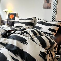 a bed with black and white comforter on top of it