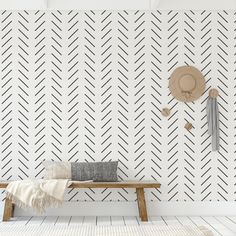 a wooden bench sitting in front of a white wall