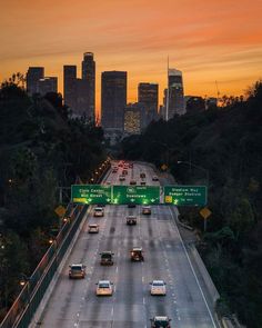 cars are driving down the highway at sunset