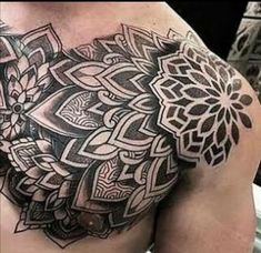 a man's chest with an intricate tattoo design on it