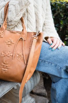 Carry your essentials in this handcrafted premium vegetable tanned leather bag, made by artisans in Buenos Aires. The unique braided design on the front with the drawing of the guarda pampa its a symbol of the southern region of Argentina associated with rural gaucho traditions. It’s the pefect accessory that goes with every outfit. • Vegetable tanned leather • Detachable shoulder strap • Interior pocket • A carabiner for your keys • Spacious main compartment • Snap closure • Unique braided deta Traditional Leather Bag With Woven Details, Traditional Woven Leather Bag, Leather Hand-stitched Satchel For Everyday, Artisan Leather Bags With Woven Detail, Hand-stitched Leather Satchel For Everyday Use, Natural Leather Satchel With Braided Handles, Artisan Woven Leather Bags, Everyday Use Hand-stitched Leather Satchel, Hand-stitched Leather Tote Satchel