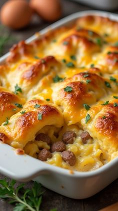 a casserole with sausage and cheese in a white dish on a wooden table