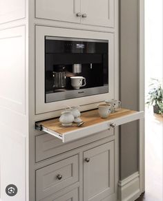 a microwave oven sitting on top of a wooden counter next to drawers and cupboards