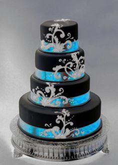 a three tiered cake with blue and black icing on it's sides