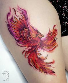 a woman's thigh with a red bird tattoo on her leg and the bottom part of her thighs