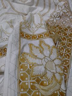 an embroidered cloth with gold and white designs on it