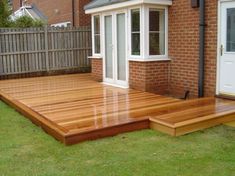 a wooden deck in front of a brick house