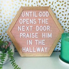 a wooden sign that says until god opens the next door, praise him in the hallway