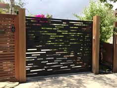 a wooden fence with flowers growing on the top and bottom part, along side it