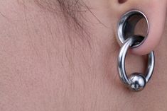 a close up of a person's ear with a pair of earrings on it