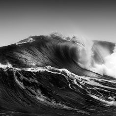 a black and white photo of a large wave