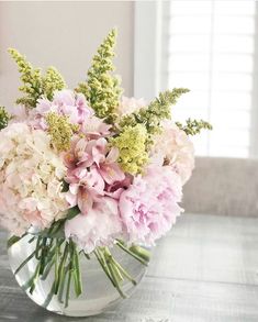 a glass vase filled with pink and white flowers