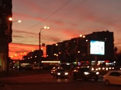 a city street filled with lots of traffic at night time as the sun goes down