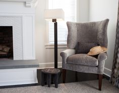 a chair with a hat on it next to a fire place in a living room