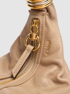 The CHLOÉ Grained Leather Bag is crafted from grained leather and features a top zip closure, a metal hoop handle, and an adjustable strap. The bag has one internal pocket and measures 21cm in height, 34cm in width, and 5cm in depth. The strap drop is 37cm, and the handle drop is 12cm.