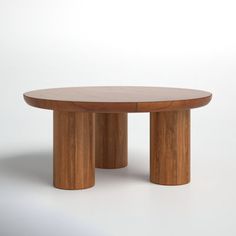 a round wooden table sitting on top of a white floor