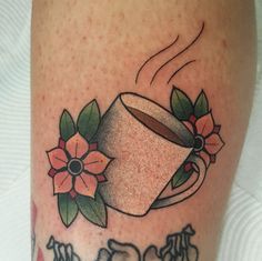 a tattoo with flowers and a coffee cup on it