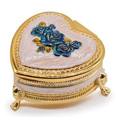 a heart shaped trinket with blue flowers on it's sides and gold trimmings